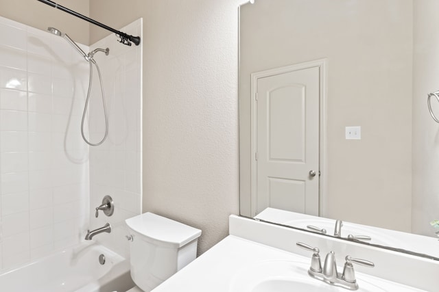 bathroom featuring tub / shower combination, a textured wall, vanity, and toilet