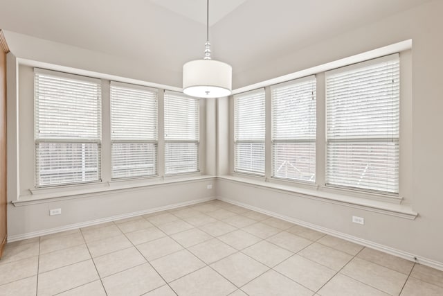 unfurnished dining area with baseboards and light tile patterned floors