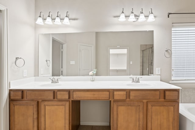 full bath featuring a garden tub, double vanity, a sink, and a shower stall