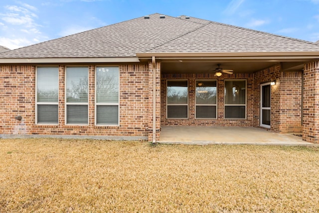 back of property with a ceiling fan, brick siding, a patio, and roof with shingles