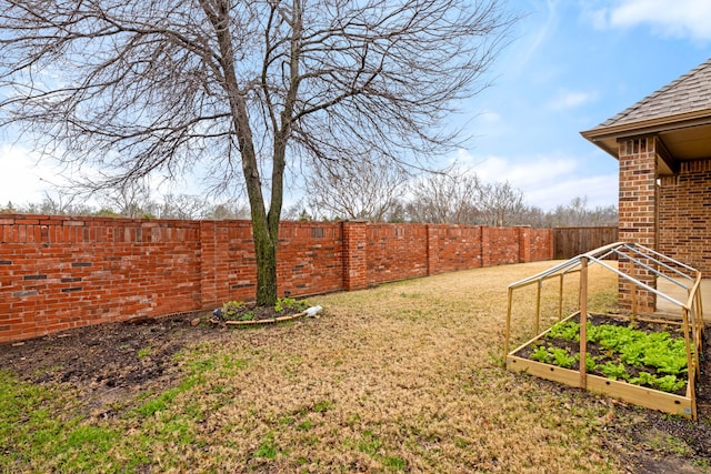 view of yard with a fenced backyard and a vegetable garden