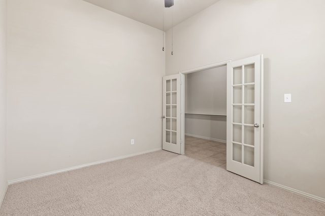 unfurnished room featuring french doors, light colored carpet, ceiling fan, and baseboards