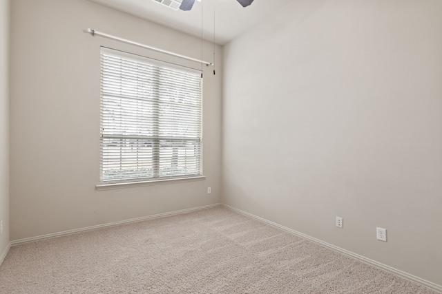 carpeted empty room featuring ceiling fan and baseboards