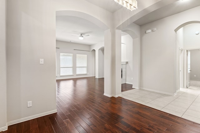 empty room featuring baseboards, light wood-style flooring, and a ceiling fan