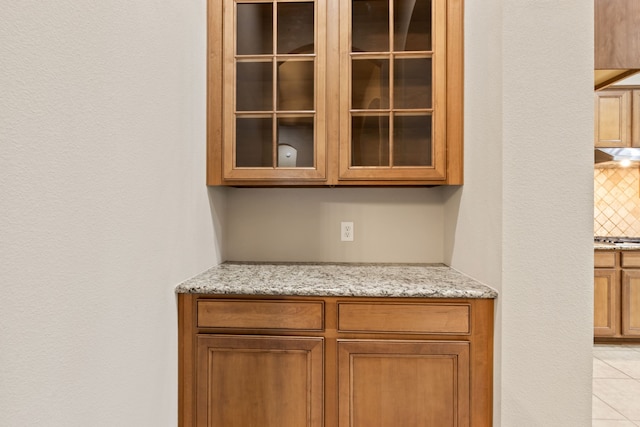 interior details featuring stainless steel gas stovetop, backsplash, and under cabinet range hood