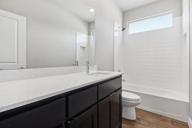 full bathroom featuring wood-type flooring, vanity, toilet, and tiled shower / bath