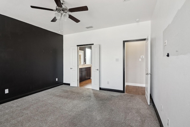 unfurnished bedroom with light carpet, ceiling fan, and connected bathroom