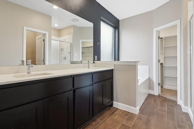 bathroom featuring vanity, independent shower and bath, and wood-type flooring