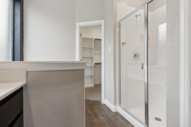 bathroom with hardwood / wood-style flooring, an enclosed shower, and vanity