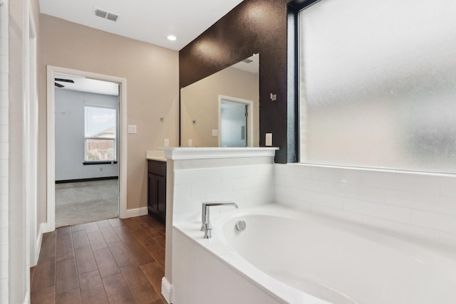 bathroom featuring a tub, wood-type flooring, and vanity