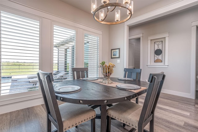 dining room with wood finished floors, a chandelier, and baseboards