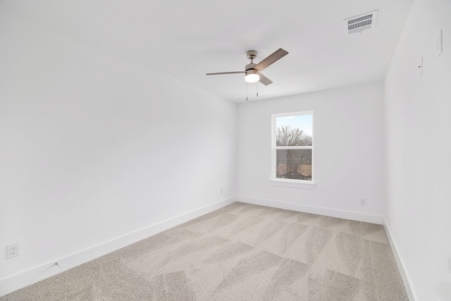 spare room with ceiling fan and light colored carpet