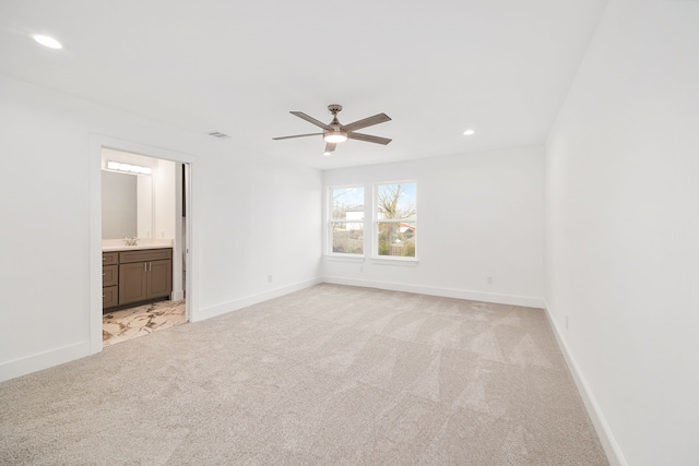 carpeted empty room featuring sink and ceiling fan