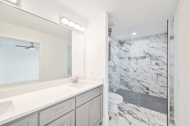 bathroom featuring vanity, ceiling fan, a shower with shower door, and toilet