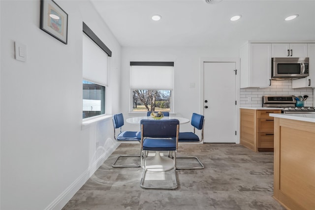 kitchen with baseboards, decorative backsplash, appliances with stainless steel finishes, light countertops, and white cabinetry