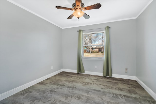 spare room with ornamental molding, wood finished floors, baseboards, and a ceiling fan