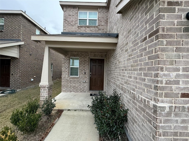 doorway to property featuring brick siding