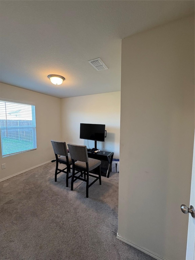 carpeted dining space with baseboards, visible vents, and a textured ceiling