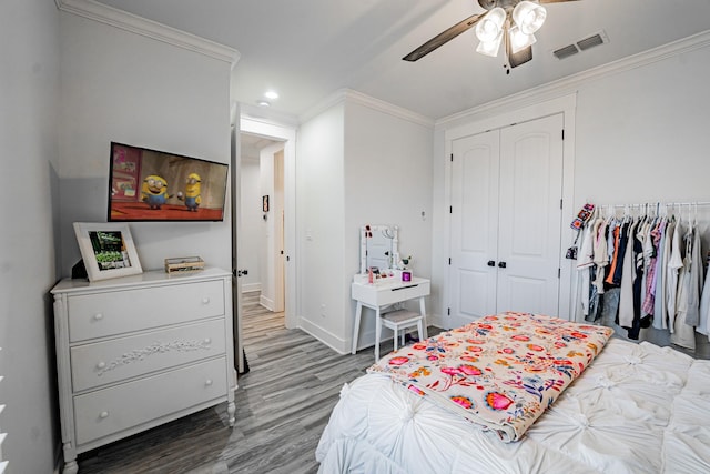 bedroom with ceiling fan, a closet, wood-type flooring, and ornamental molding