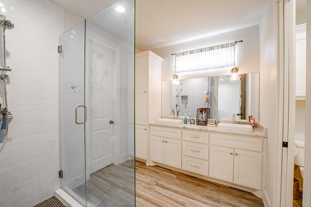 bathroom with vanity, walk in shower, and wood-type flooring