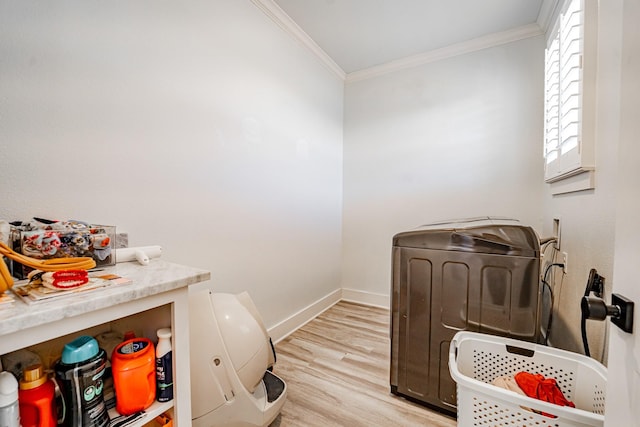 interior space with washing machine and dryer, crown molding, and light hardwood / wood-style floors