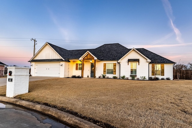 view of front of home with a garage and a lawn