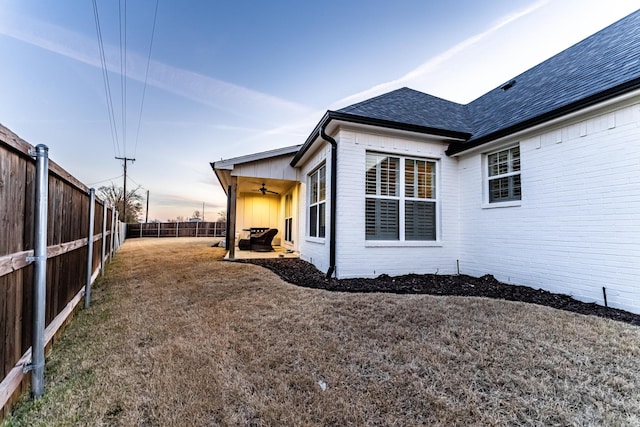 property exterior at dusk featuring ceiling fan