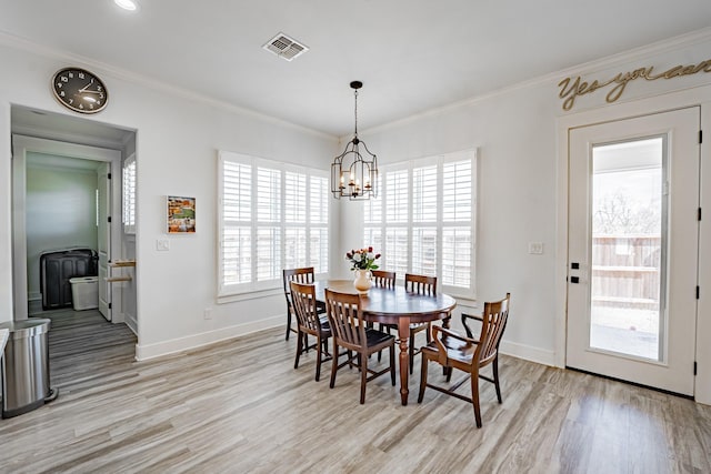 dining area featuring a wealth of natural light, crown molding, a chandelier, and light hardwood / wood-style flooring