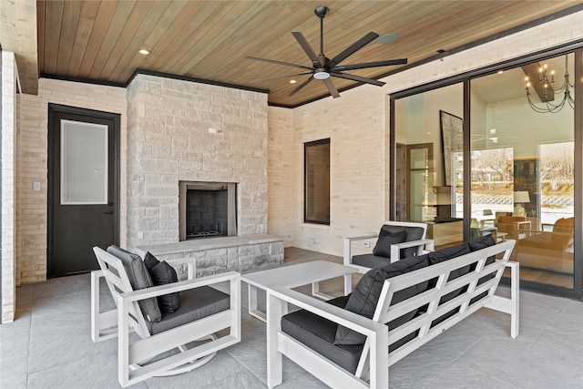 view of patio featuring ceiling fan and an outdoor living space with a fireplace