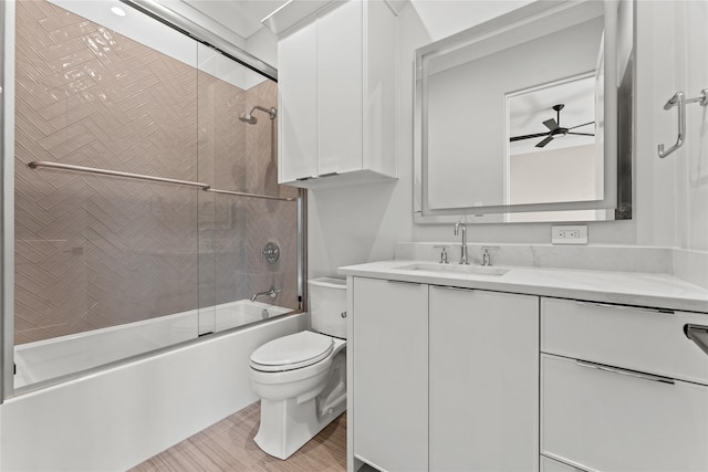 bathroom with shower / bath combination with glass door, vanity, toilet, and a ceiling fan