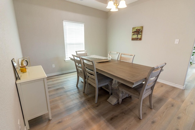 dining area featuring an inviting chandelier and hardwood / wood-style floors