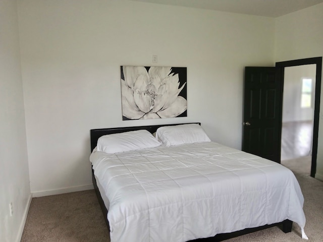bedroom featuring baseboards and carpet