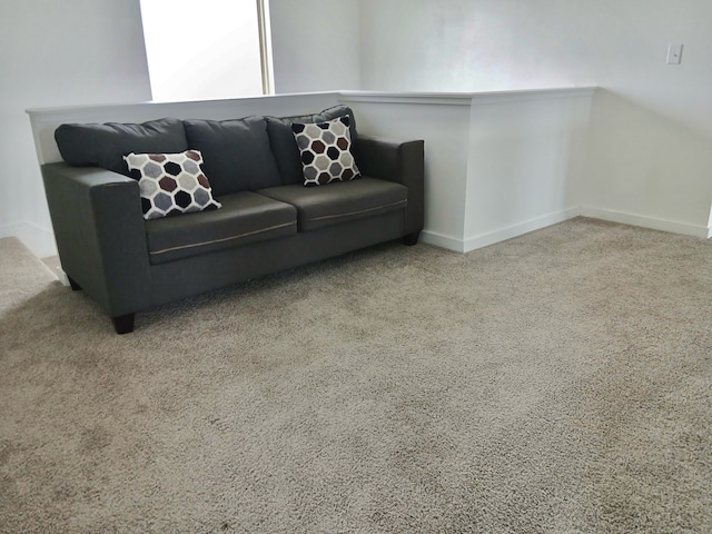carpeted living area featuring baseboards