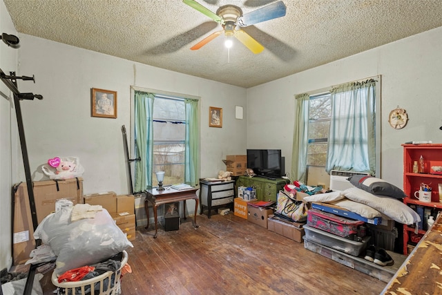 miscellaneous room with cooling unit, ceiling fan, dark wood-type flooring, and a textured ceiling