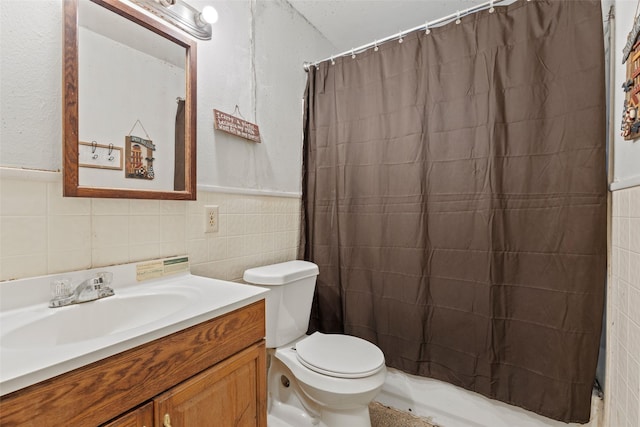 bathroom featuring toilet, tile walls, and vanity