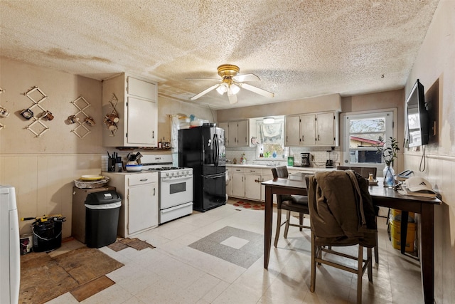 kitchen featuring tasteful backsplash, a textured ceiling, ceiling fan, white gas stove, and black fridge