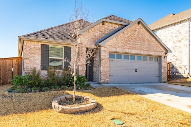 view of front of home with a garage, concrete driveway, brick siding, and fence