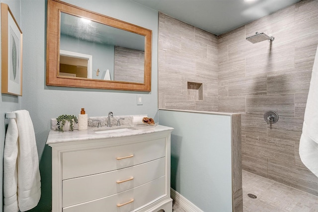 bathroom with vanity and tiled shower