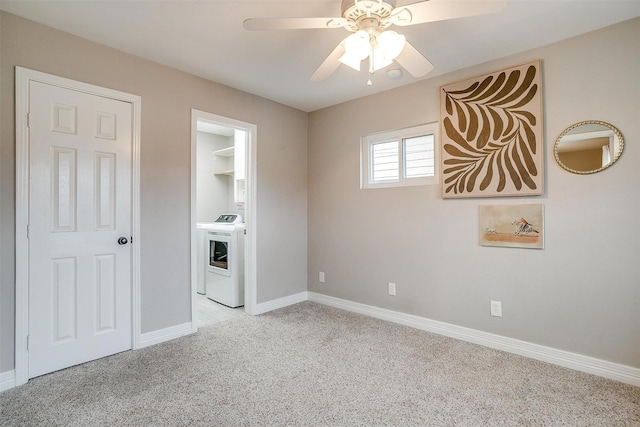 interior space featuring ceiling fan, washer and dryer, and light colored carpet