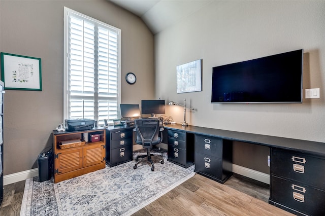 office area featuring light wood-type flooring and vaulted ceiling