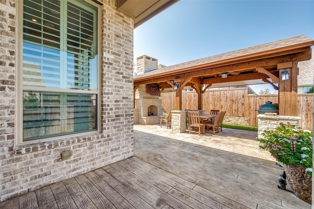 view of patio with an outdoor fireplace and a wooden deck