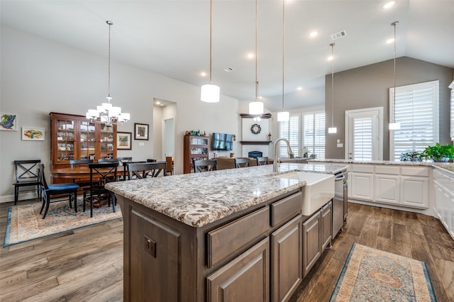 kitchen with hanging light fixtures, an island with sink, white cabinetry, and dark hardwood / wood-style floors