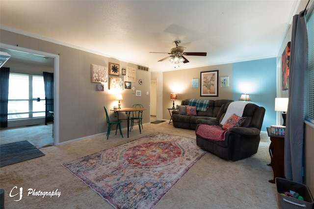 living room with carpet flooring, crown molding, and ceiling fan