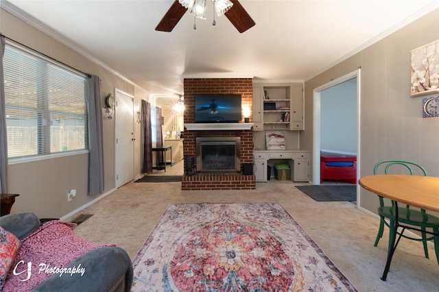 carpeted living room featuring a fireplace, ornamental molding, and ceiling fan