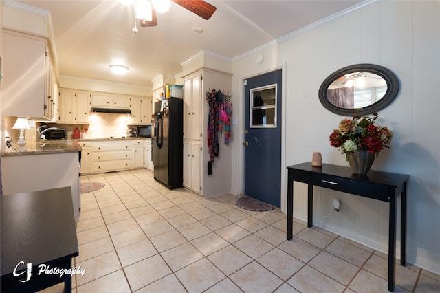 kitchen featuring ornamental molding, black appliances, light stone countertops, and decorative backsplash