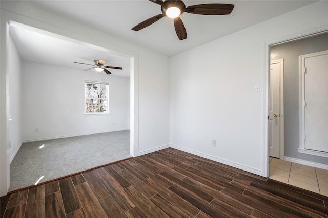 spare room with ceiling fan and dark wood-type flooring