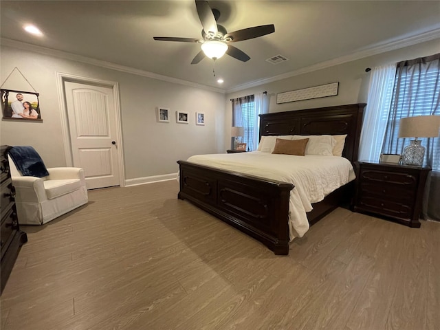 bedroom with ornamental molding, hardwood / wood-style flooring, and ceiling fan