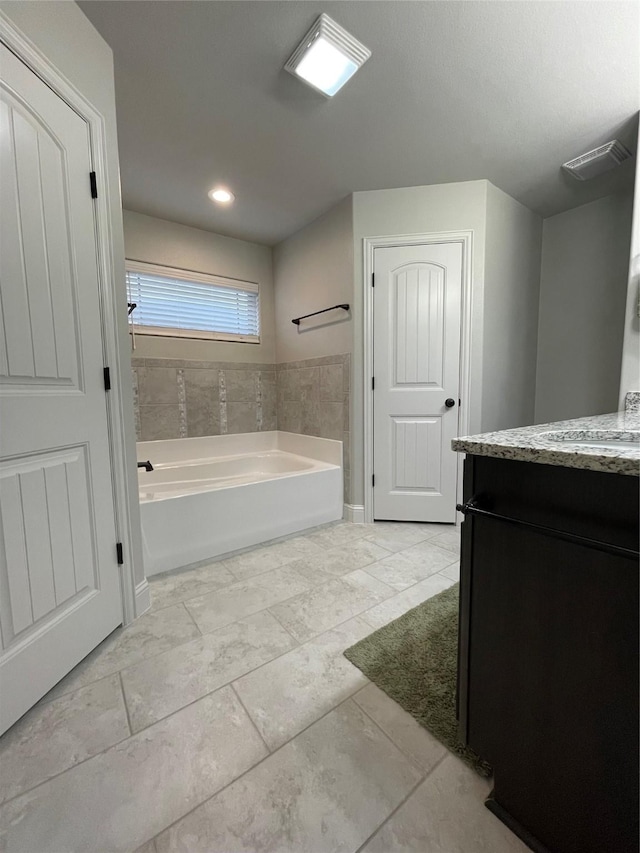 bathroom with vanity and a tub to relax in