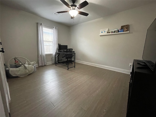 office space featuring ceiling fan and dark hardwood / wood-style flooring