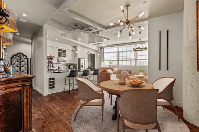 dining area featuring dark wood-type flooring and an inviting chandelier